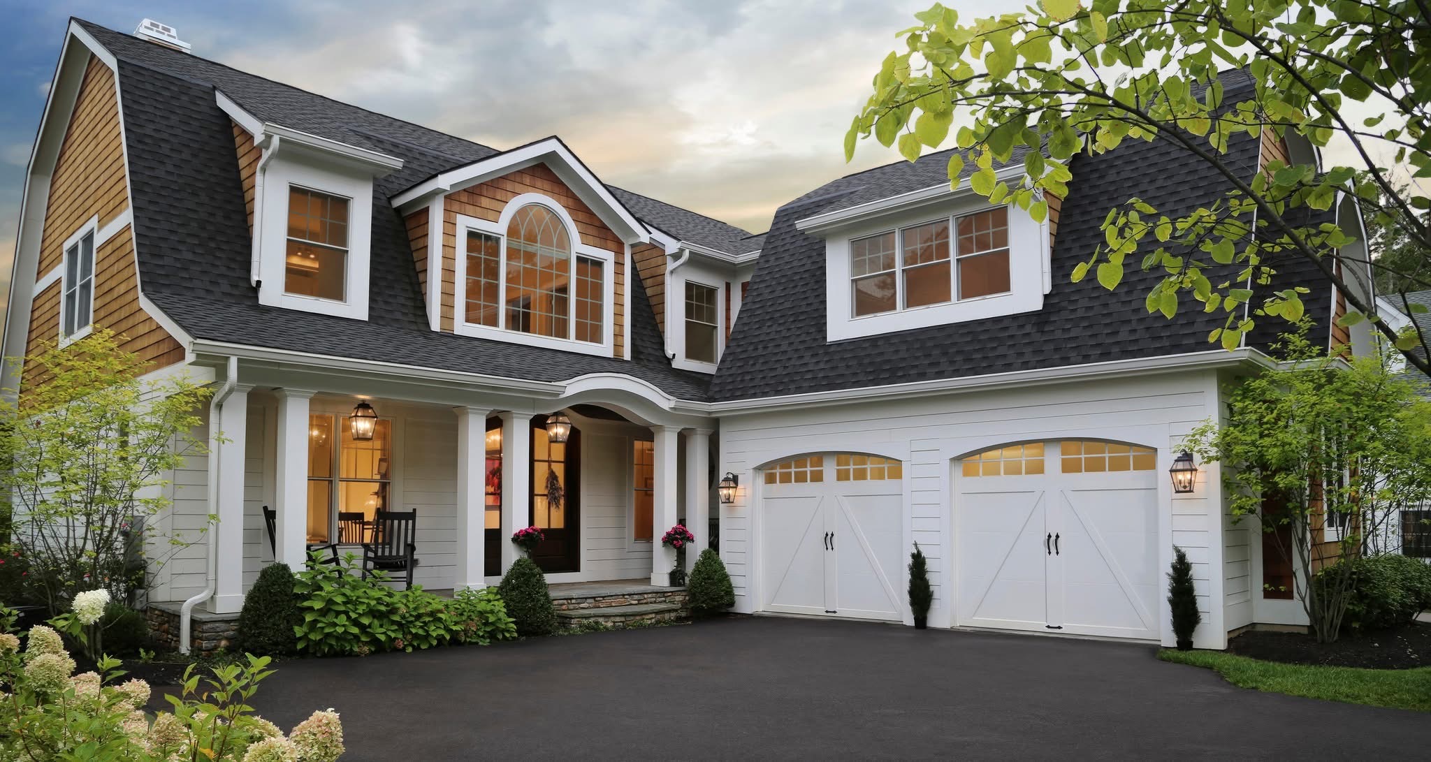 White carriage house garage doors with decorative hardware on craftsman-style home