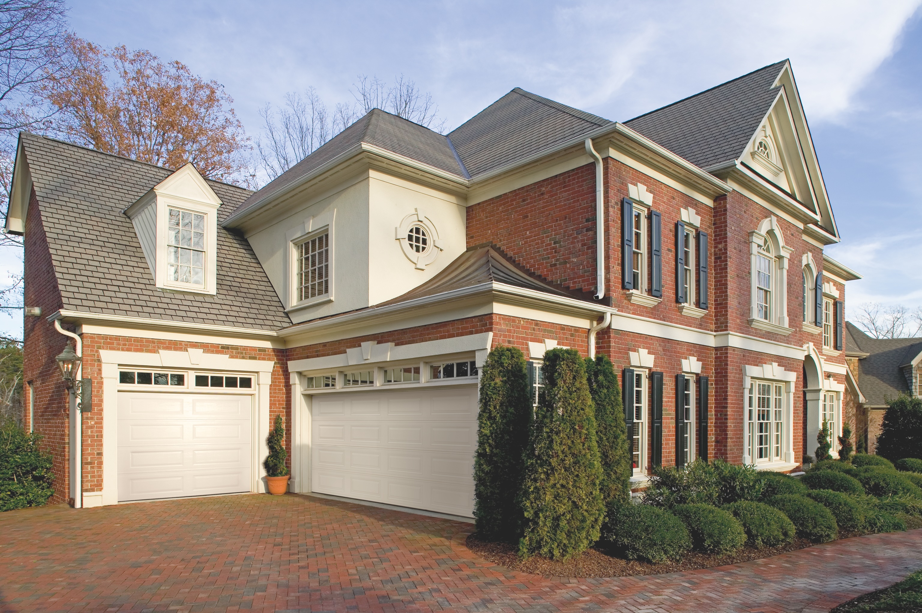 Insulated steel garage door with window panels on modern dark-sided home in Metro Vancouver