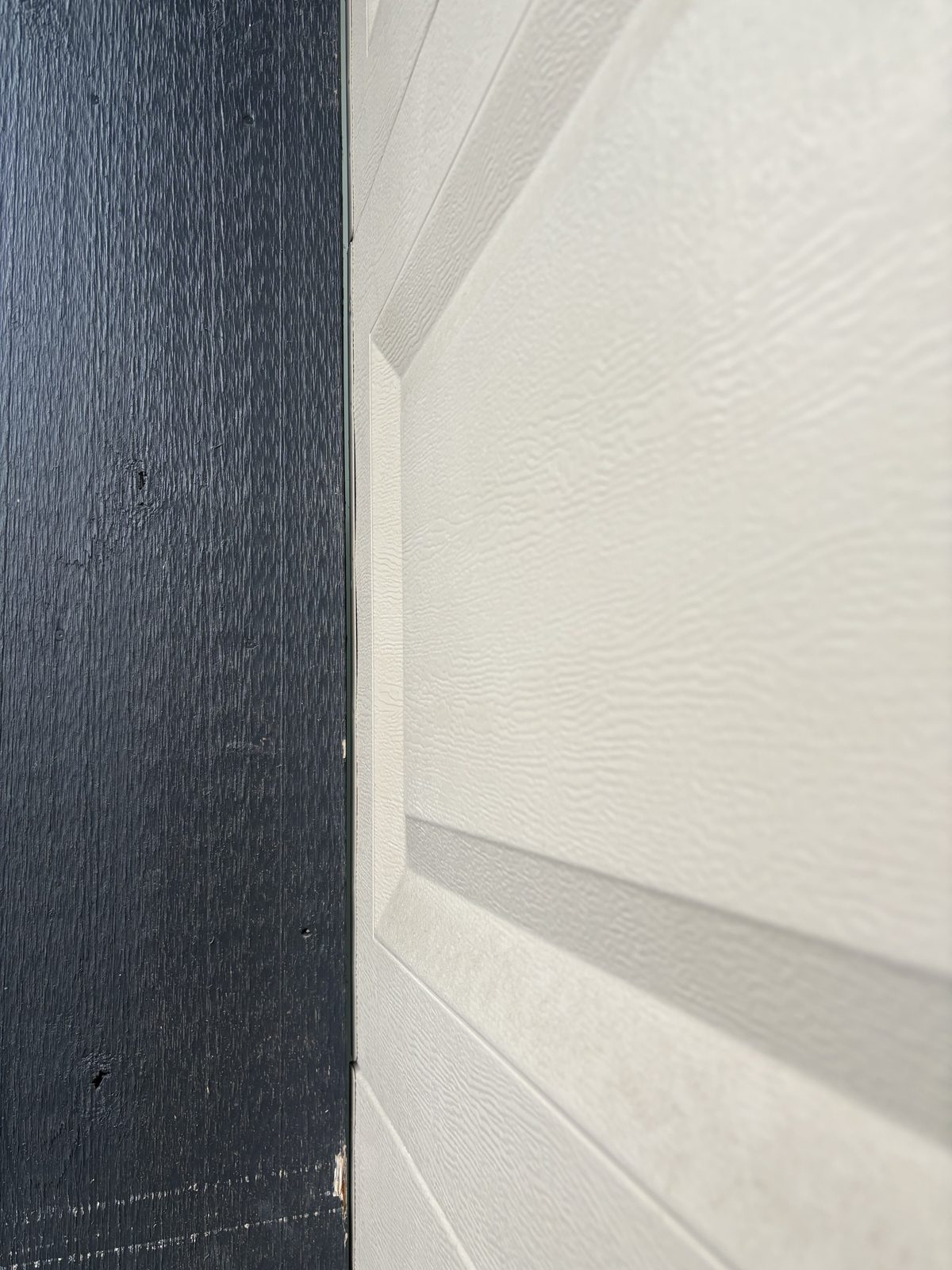 Garage door frame without vinyl weather stop showing gap between frame and door panel — Lower Mainland
