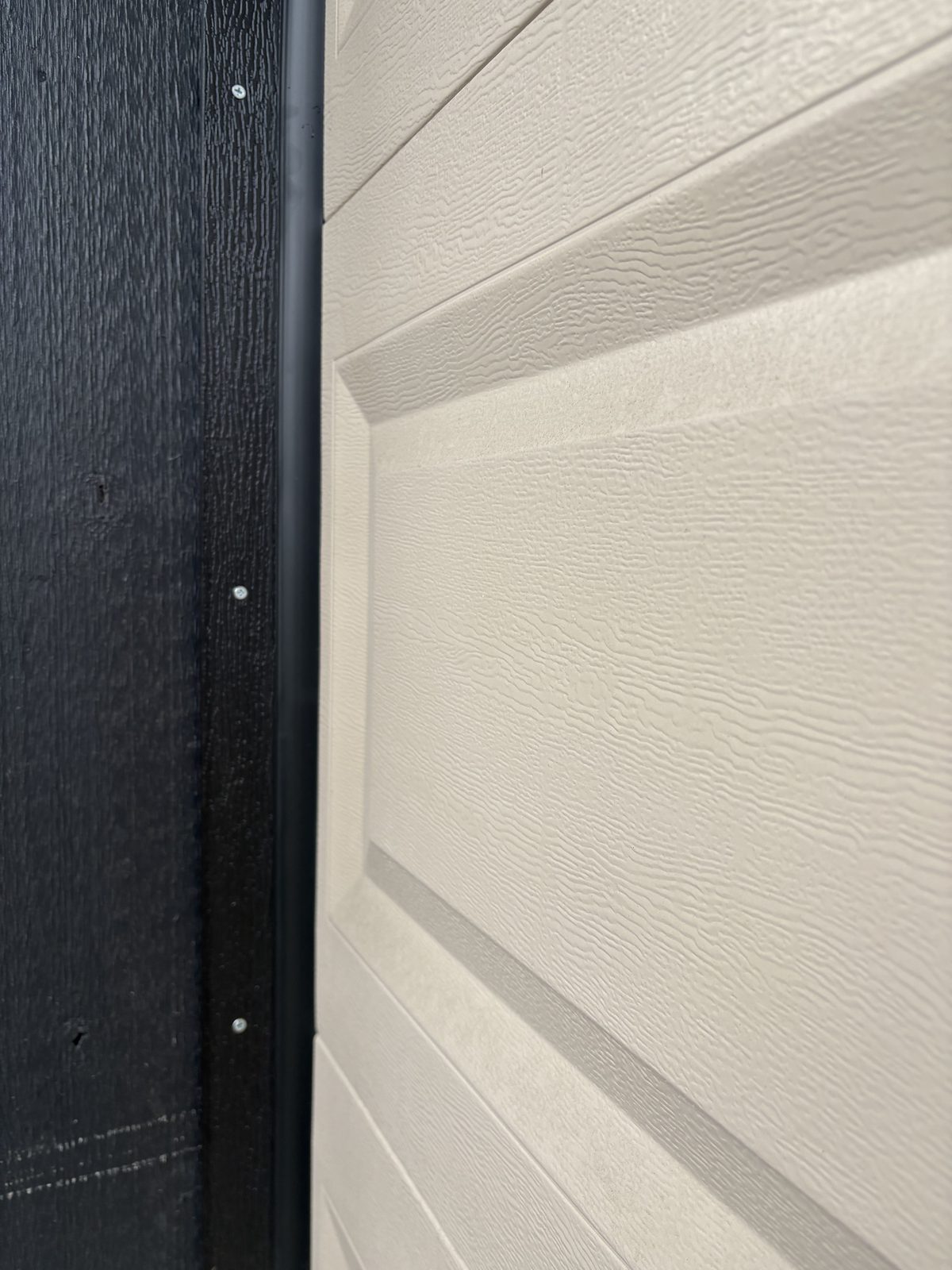 Vinyl weather stop installed on garage door side frame — after installation